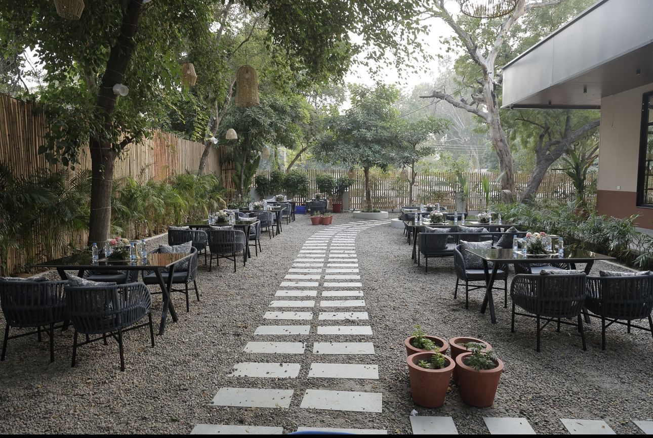 Tables along a stone-slab path through the gravel garden by day