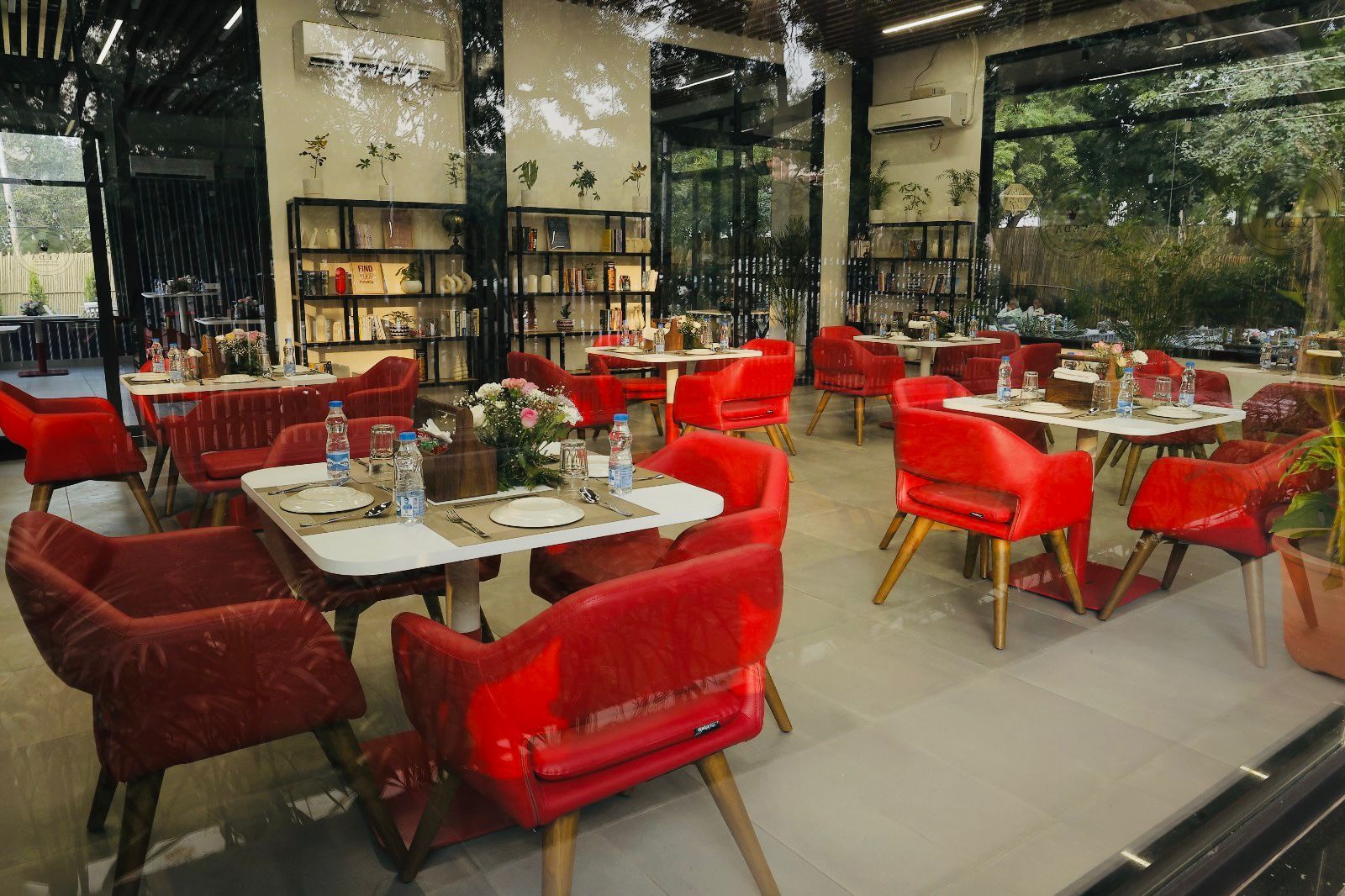 The dining room: red upholstered chairs and white tables