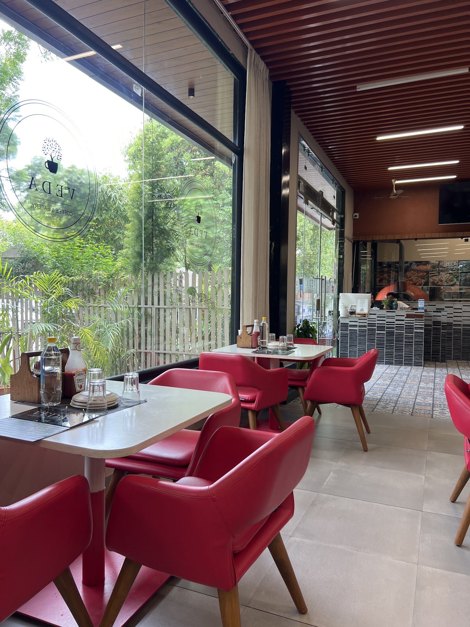 Red chairs by tall windows looking onto the garden